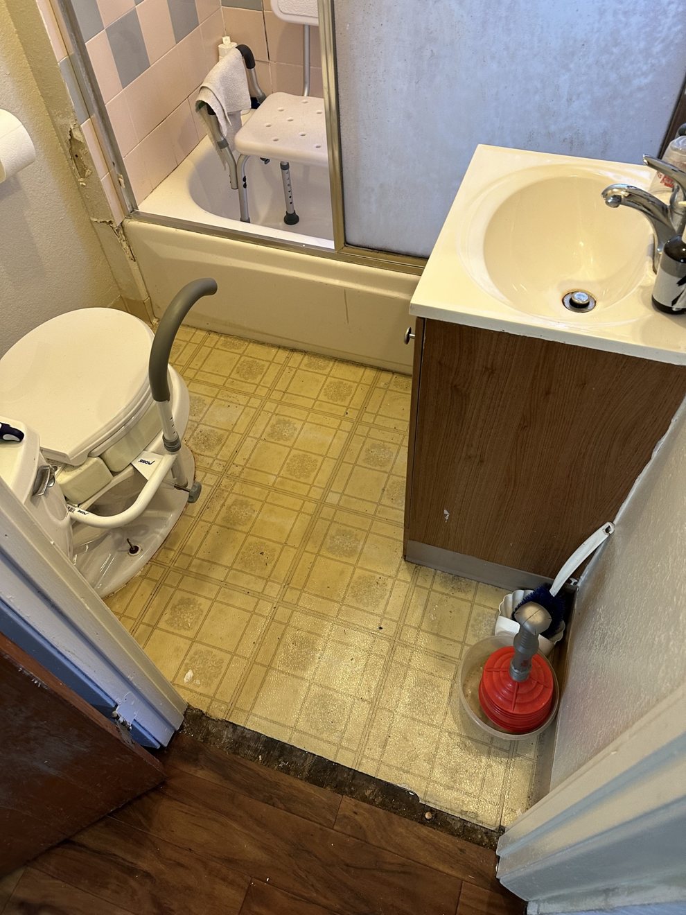 Bathroom with worn yellow linoleum floor before renovation
