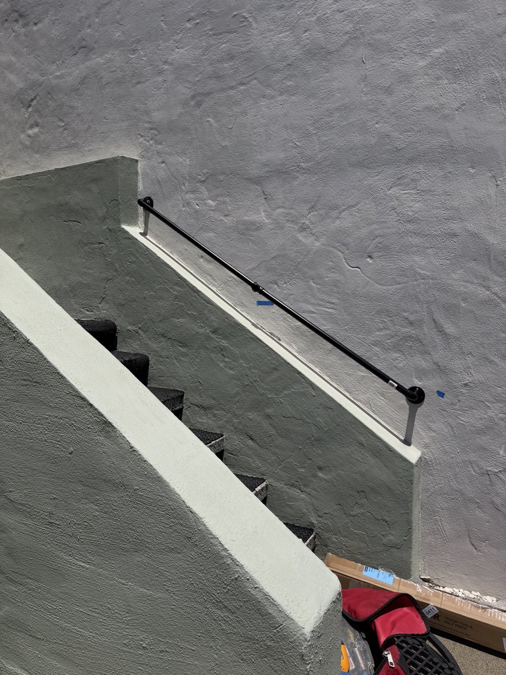 New black metal handrail installed on an outdoor staircase